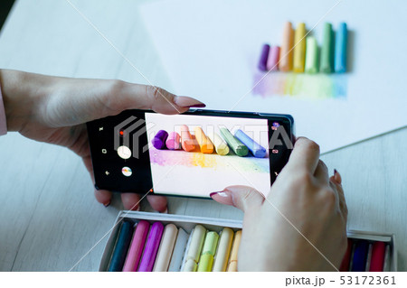 A girl takes on the smartphone multicolored chalks A girl takes on the smartphone multicolored chalks 53172361