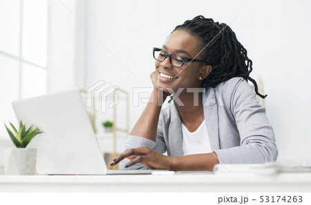 African-American Woman Looking At Laptop Screen In Office African-American Woman Looking At Laptop Screen In Office 53174263