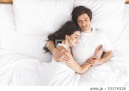 Loving couple sleeping in bed and hugging 53174326