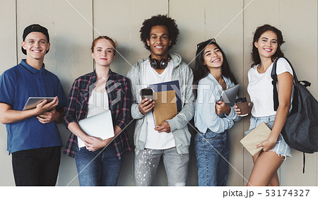 Multiethnic group of cheerful young students standing together Multiethnic group of cheerful young students standing together 53174327