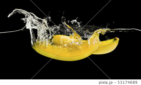 Ripe yellow bananas dropped into water on black Ripe yellow bananas dropped into water on black 53174689
