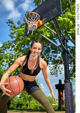 Beautiful sexy fitness girl in black sport wear with perfect body with basket ball at basketball 53175629