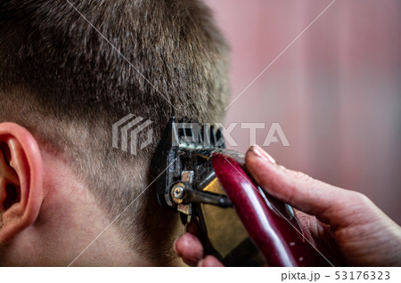 Close up of a male student having a haircut with hair clippers 53176323