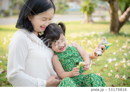Grandmother and granddaughter sitting in park 53179816