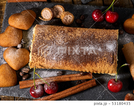 Oatmeal cookies ,rolled cake on tier cake stand with cherry 53180435
