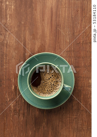 A cup of coffee on a dark rustic wooden background, shot from the top with a place for text A cup of coffee on a dark rustic wooden background, shot from the top with a place for text 53184110