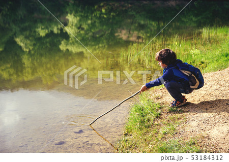 Child play fishing near lake. Child play fishing near lake. 53184312