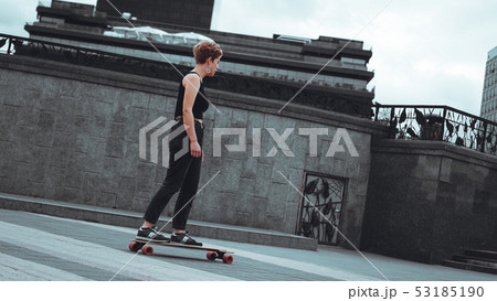 Young sporty woman riding on the longboard Young sporty woman riding on the longboard 53185190