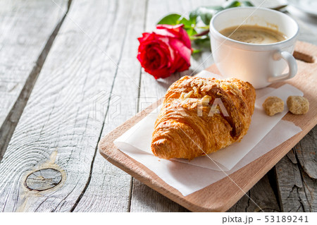 Delicious fresh croissants with coffee and rose 53189241