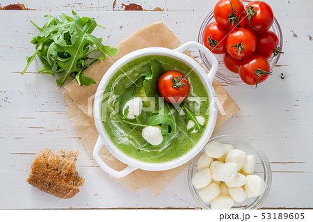 Arugula and tomatoes puree soup in white bowl 53189605