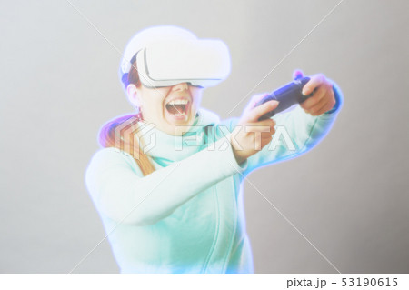 Woman with virtual reality headset is playing game. Image with hologram effect. Woman with virtual reality headset is playing game. Image with hologram effect. 53190615