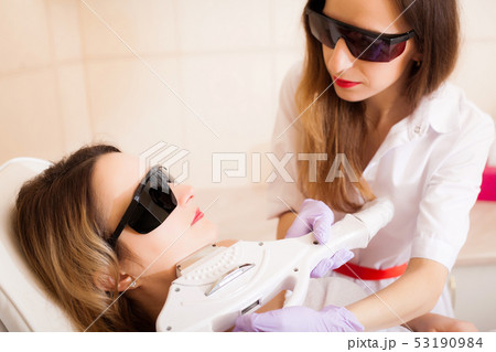 Body Care. Close-up of Beautician Giving Laser Epilation Treatment To Young Woman Face Body Care. Close-up of Beautician Giving Laser Epilation Treatment To Young Woman Face 53190984