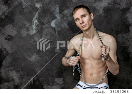 Handsome naked skinny guy holding a chain. Black Handsome naked skinny guy holding a chain. Black 53192068