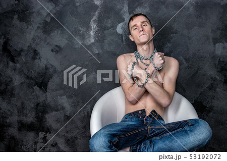 Handsome skinny guy holding a chain. Black 53192072