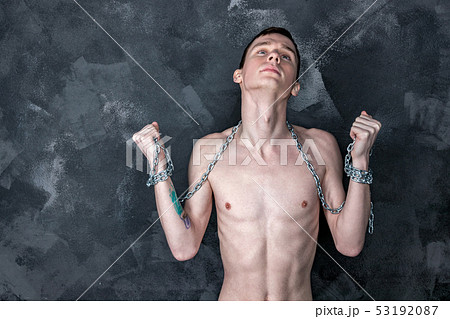 Handsome skinny guy holding a chain. Black 53192087