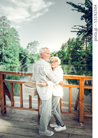 Full-sized shot of woman hugging a white-haired attractive spouse Full-sized shot of woman hugging a white-haired attractive spouse 53192504