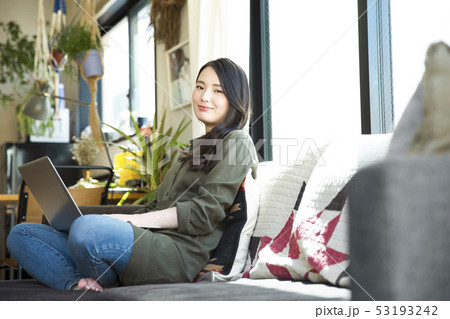 女性　若い女性　パソコン　リビング　ソファ　ライフスタイル　リラックス　スマイル　笑顔　 53193242