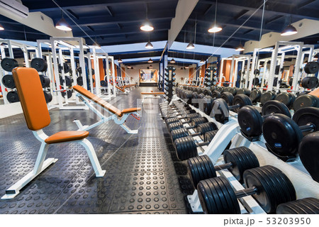 New fitness machines and dumbbells in modern gym interior 53203950