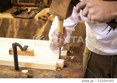 carpenter's hands working a piece of wood 53204305