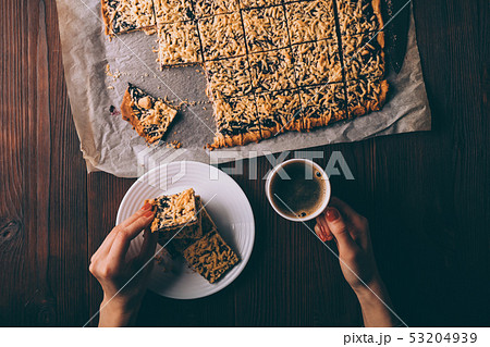 Woman's hands holding cookies and cup of coffee 53204939