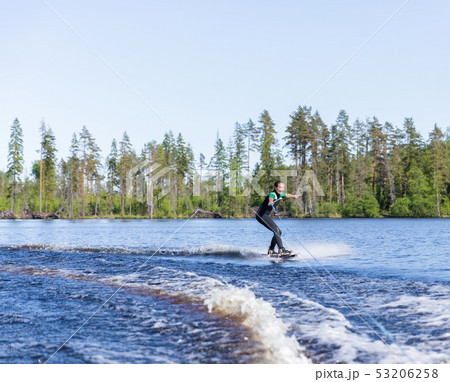 Young pretty slim brunette woman in wetsuit riding 53206258