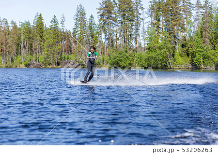 Young pretty slim brunette woman in wetsuit riding Young pretty slim brunette woman in wetsuit riding 53206263