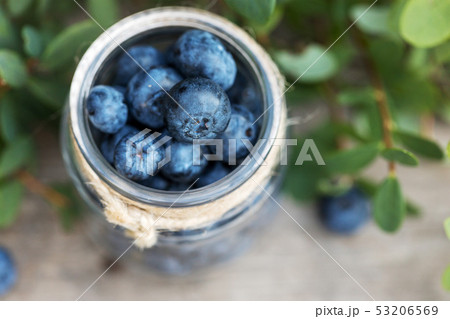 Fresh raw blueberries with leaves on wooden 53206569
