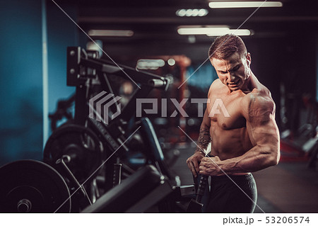 Strong Bodybuilder Doing Heavy Weight Exercise For Back On Machine 53206574