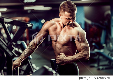 Strong Bodybuilder Doing Heavy Weight Exercise For Back On Machine 53206576