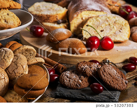 Sand chocolate cookies heart shape and rolled cake with cherry Sand chocolate cookies heart shape and rolled cake with cherry 53207303