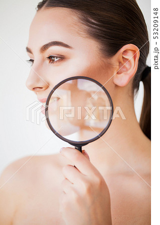 Woman Looking Through Magnifier And Smiling Close Up Woman Looking Through Magnifier And Smiling Close Up 53209148
