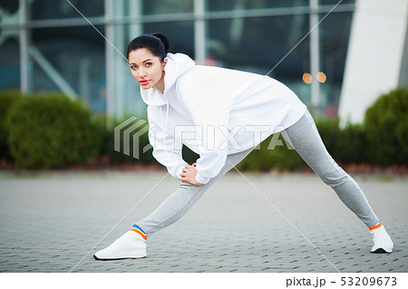 Fitness girl. Young sports woman stretching in the modern city. Healthy lifestyle in the big city Fitness girl. Young sports woman stretching in the modern city. Healthy lifestyle in the big city 53209673