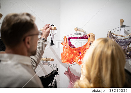 Husband and wife shopping at the lingerie store. Husband and wife shopping at the lingerie store. 53216035