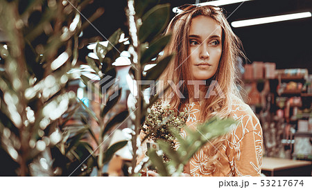 Young woman buying flowers at a garden center 53217674