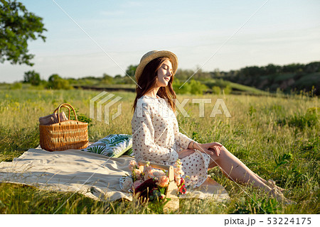 Happy Woman Life Style, beautiful relaxed girl in a straw hat on the nature picnic basket flowers in Happy Woman Life Style, beautiful relaxed girl in a straw hat on the nature picnic basket flowers in 53224175