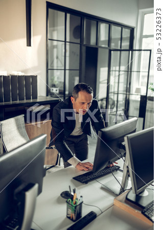 Mature dark-haired businessman checking his e-mail on computer 53226373