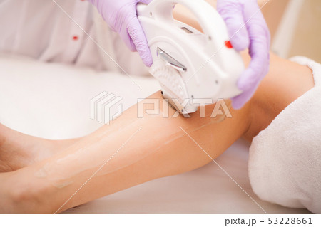Skin Care. Hair removal on the legs, laser procedure at clinic. Beautician removes hair on beautiful Skin Care. Hair removal on the legs, laser procedure at clinic. Beautician removes hair on beautiful 53228661