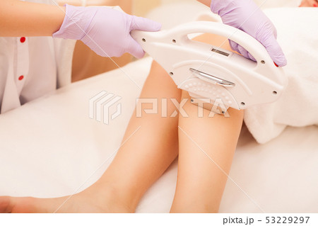 Skin Care. Hair removal on the legs, laser procedure at clinic. Beautician removes hair on beautiful Skin Care. Hair removal on the legs, laser procedure at clinic. Beautician removes hair on beautiful 53229297