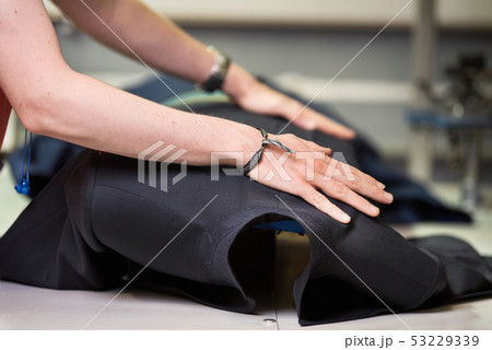 Ironing table. Industrial Presser in sewing suit clothes pressed. 53229339