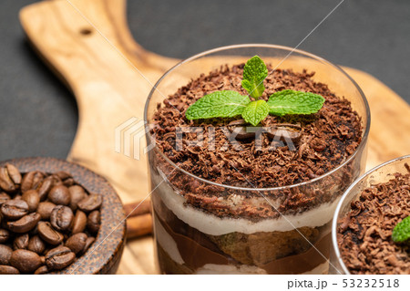 Classic tiramisu dessert in a glass on dark concrete background 53232518