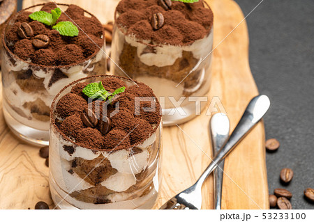 Classic tiramisu dessert in a glass on dark concrete background 53233100