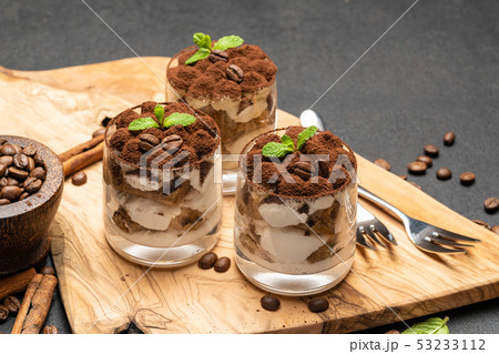 Classic tiramisu dessert in a glass on dark concrete background 53233112