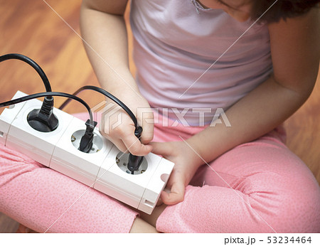 Little child playing with plug 53234464