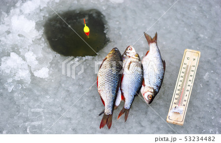 Ice hole fishing. Winter fishing in freezing cold 53234482