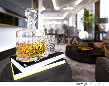 A decanter with brandy and a glass is on the book A decanter with brandy and a glass is on the book 53234859