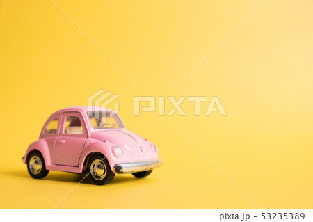 Pink retro toy car on yellow background. Pink retro toy car on yellow background. 53235389