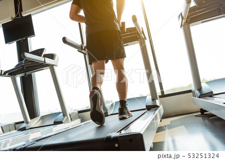 Legs of sportsman running on treadmill in fitness 53251324