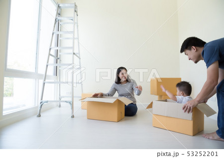 Family unpacking boxes in new home on moving day, 53252201