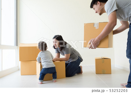 Family unpacking boxes in new home on moving day, 53252203