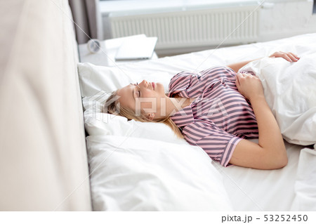 calm pleasant girl in pajama lying in the bed 53252450